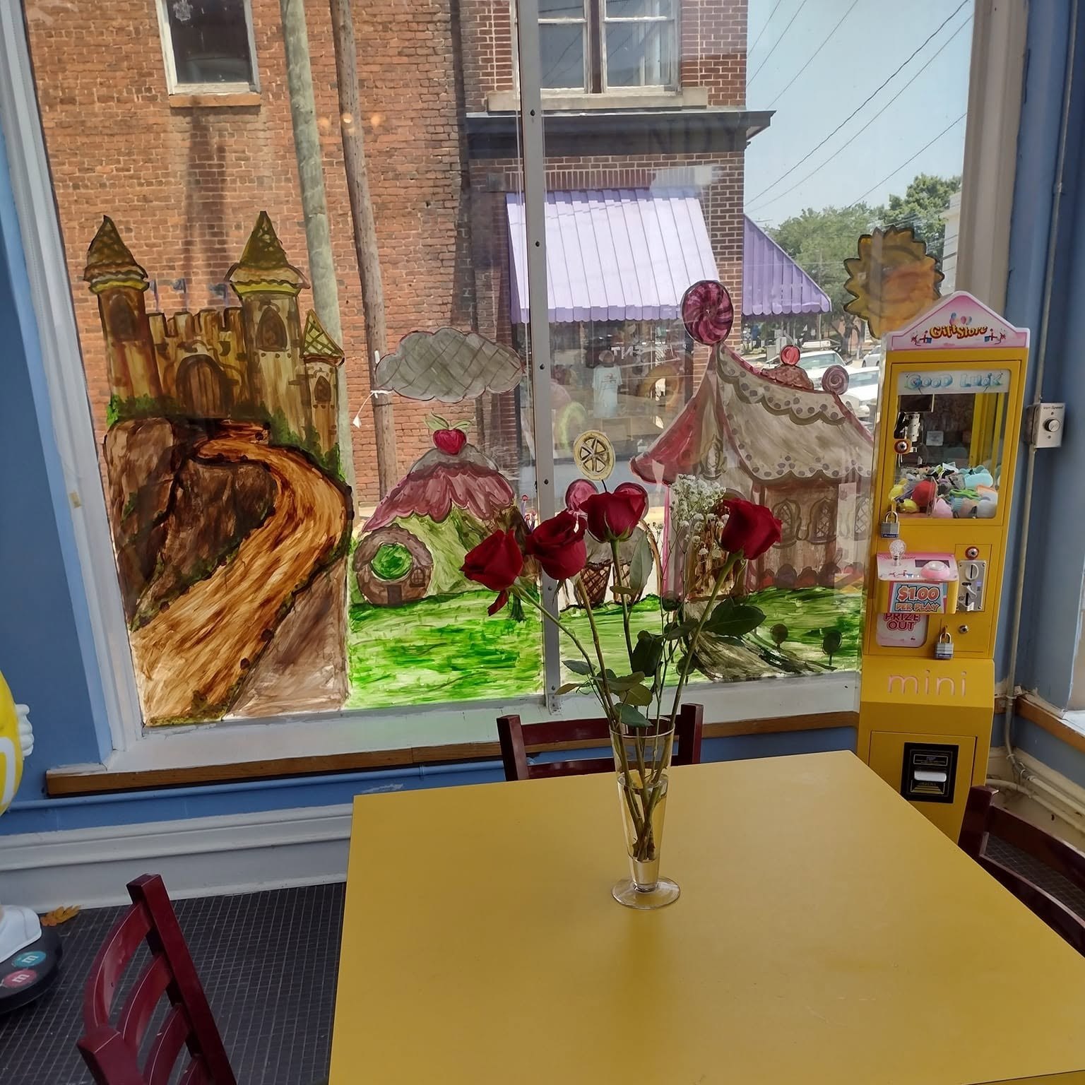 A table with roses beside the hand-painted front window inside The Candy Shoppe on Main