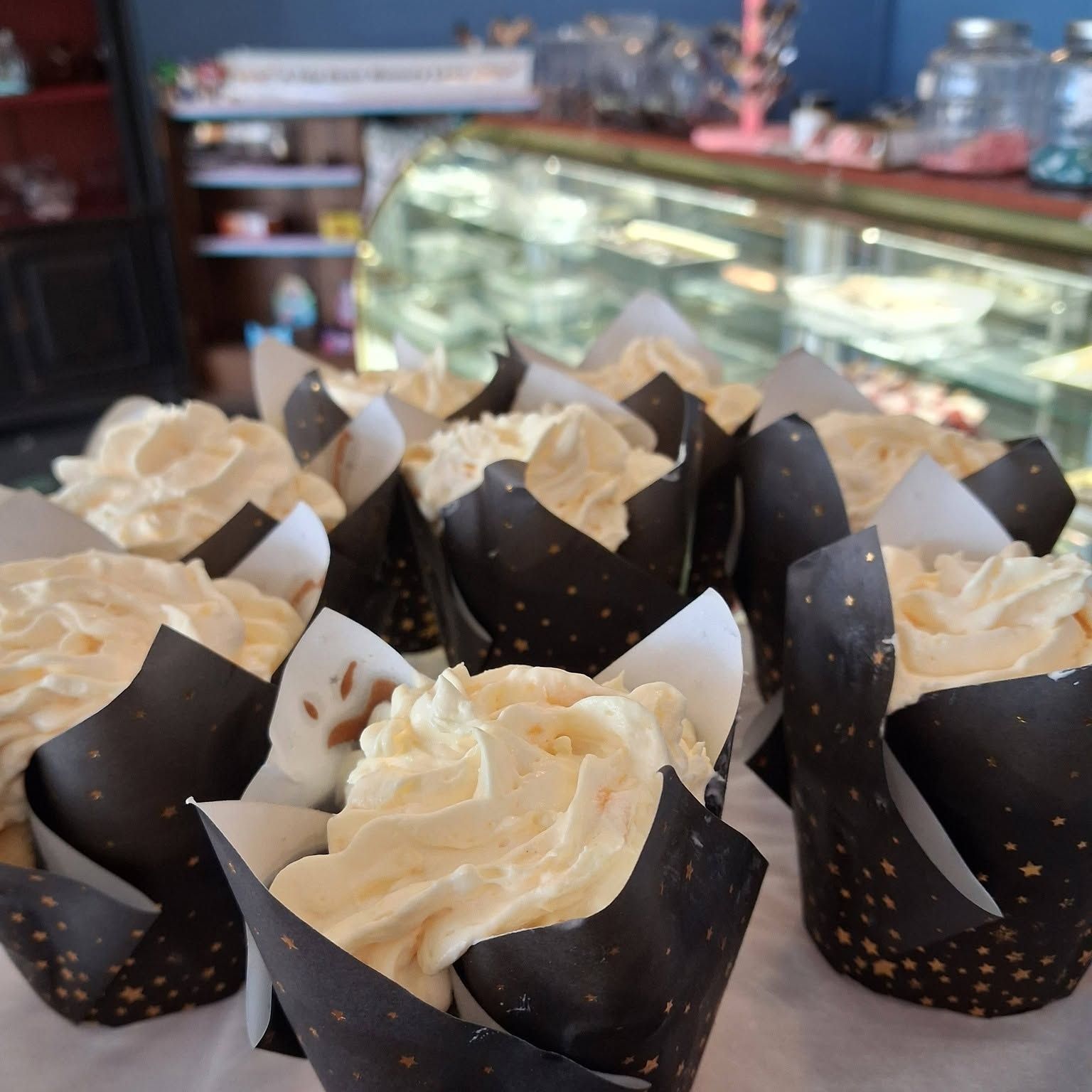 Fresh cupcakes in wrappers at the counter of The Candy Shoppe on Main