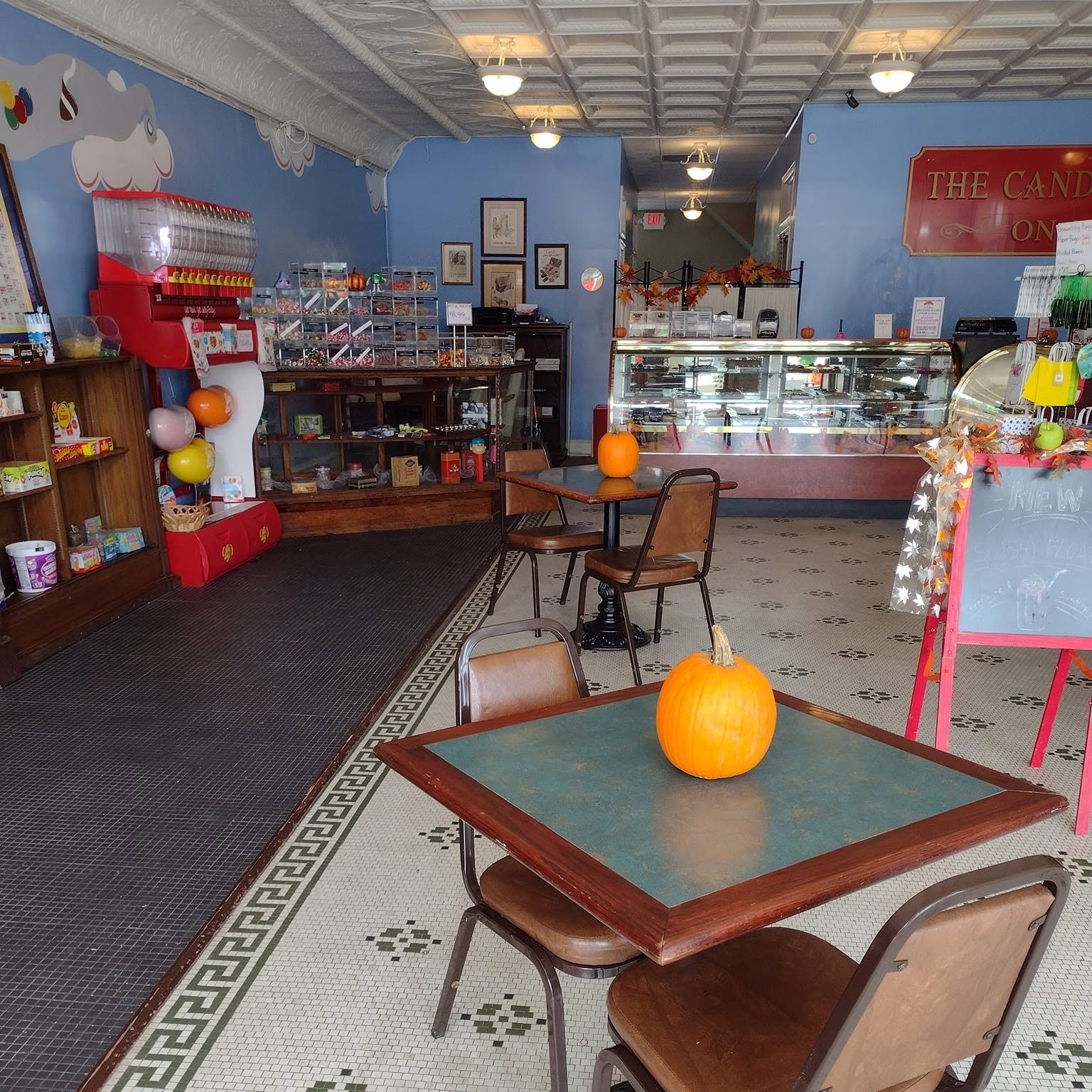 The dine-in room with tables and candy displays inside The Candy Shoppe on Main