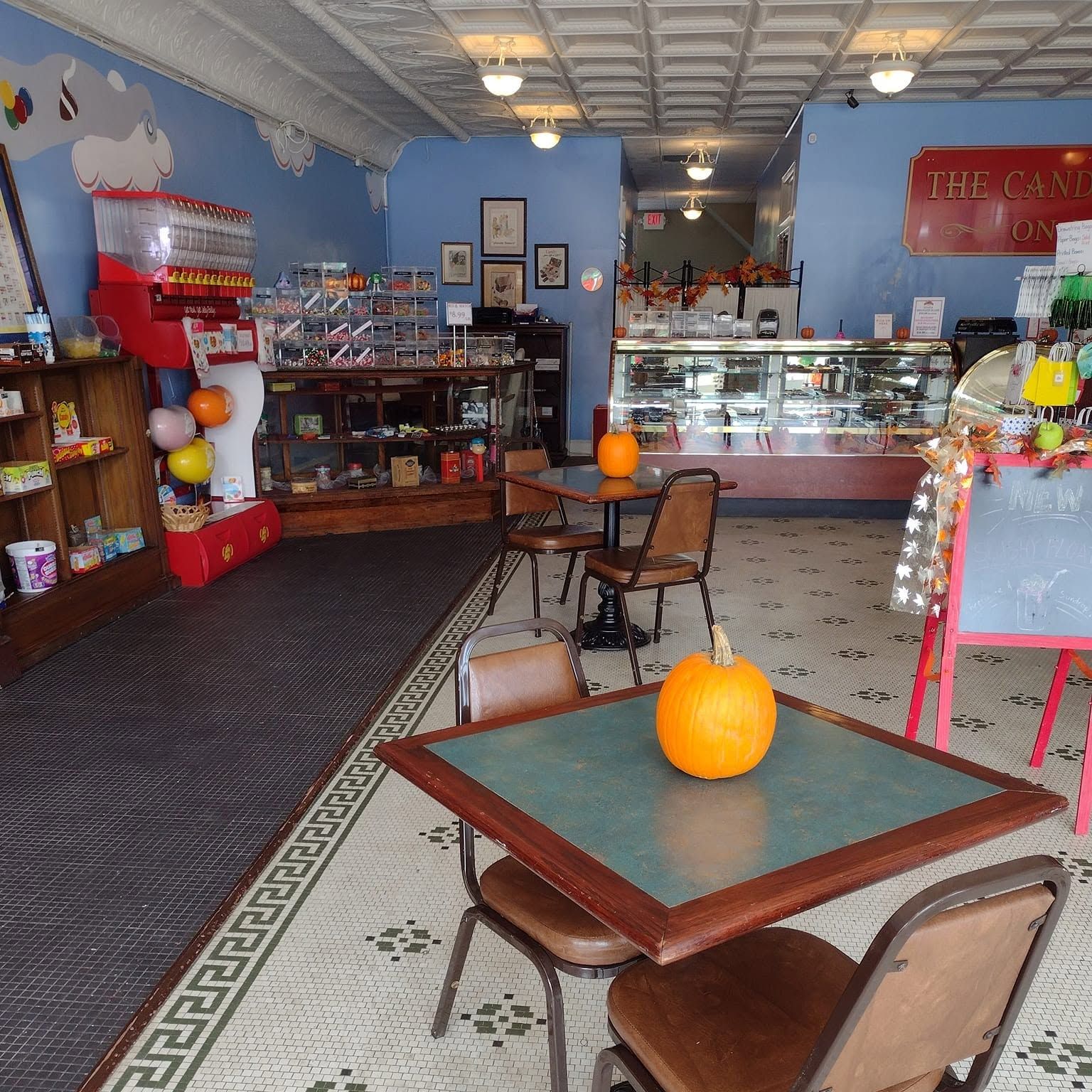 Dine-in tables on the tile floor inside The Candy Shoppe on Main