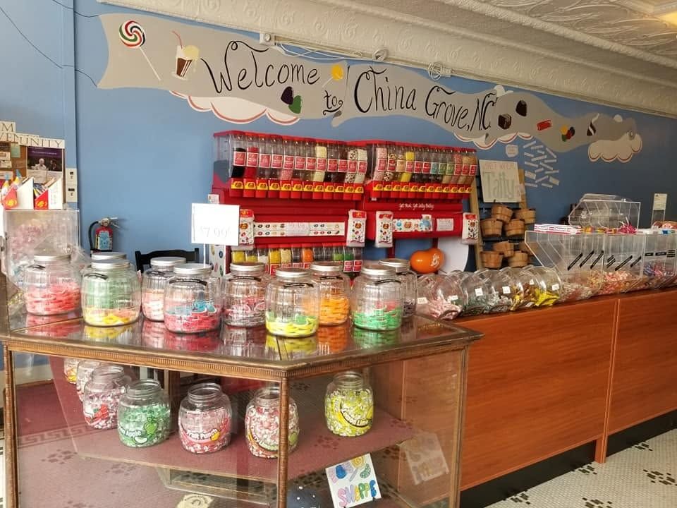 Jars of candy on shelves beneath the Welcome to China Grove mural at The Candy Shoppe on Main