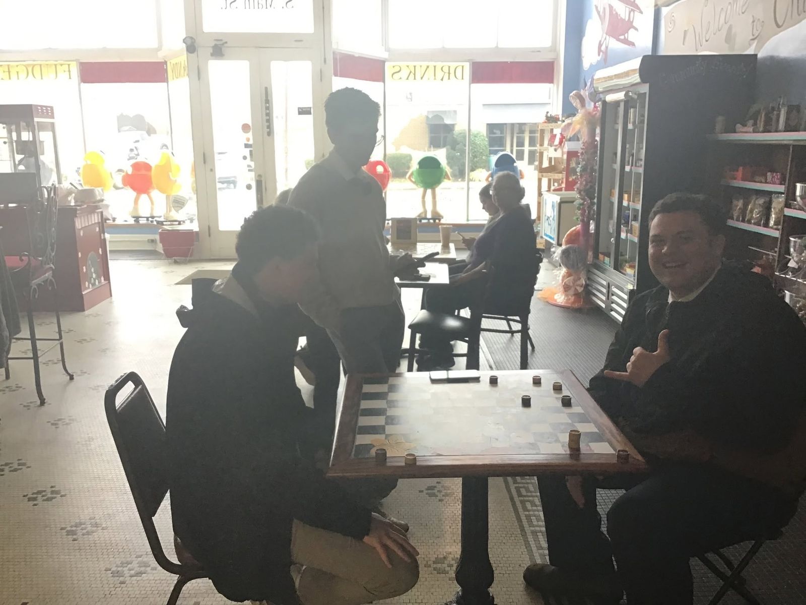 Customers playing checkers by the front windows at The Candy Shoppe on Main