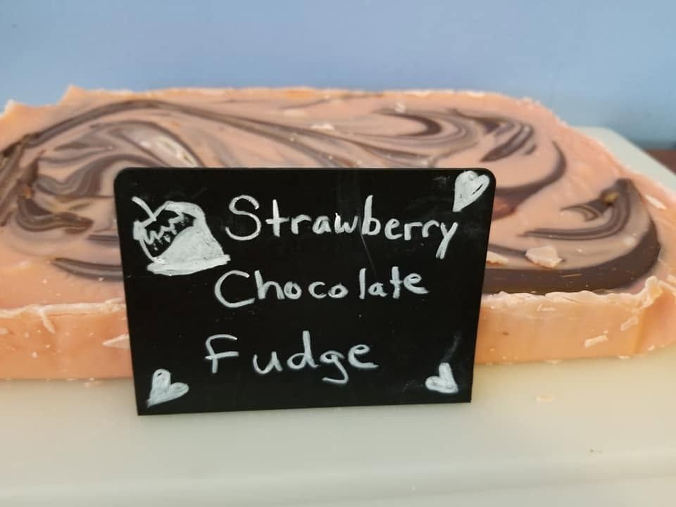 Strawberry chocolate fudge slab with its chalk label at The Candy Shoppe on Main
