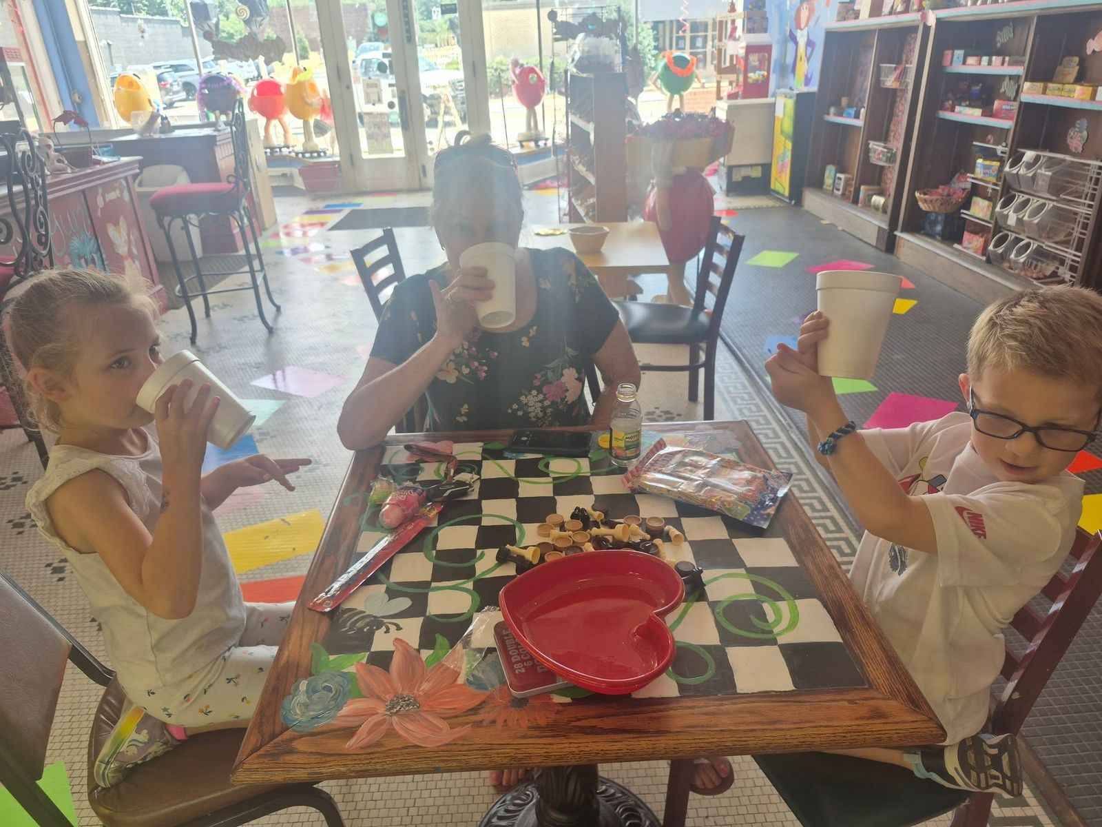 Kids playing checkers at a table inside The Candy Shoppe on Main