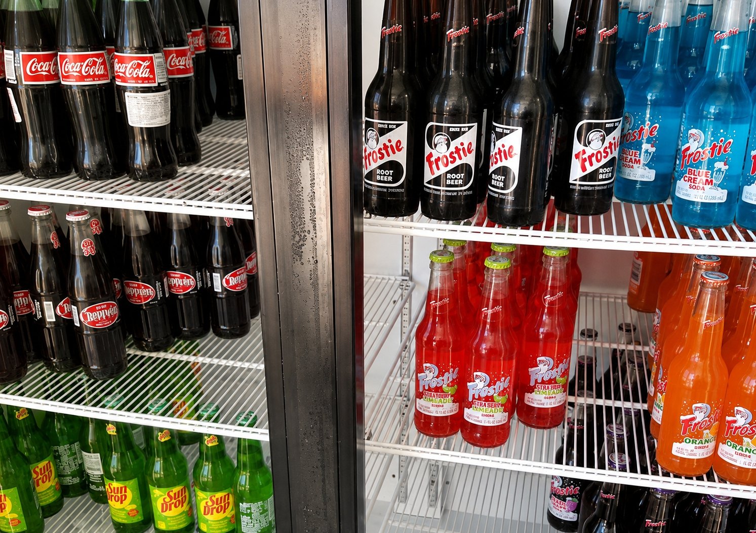 Cooler shelves of glass bottle sodas at The Candy Shoppe on Main