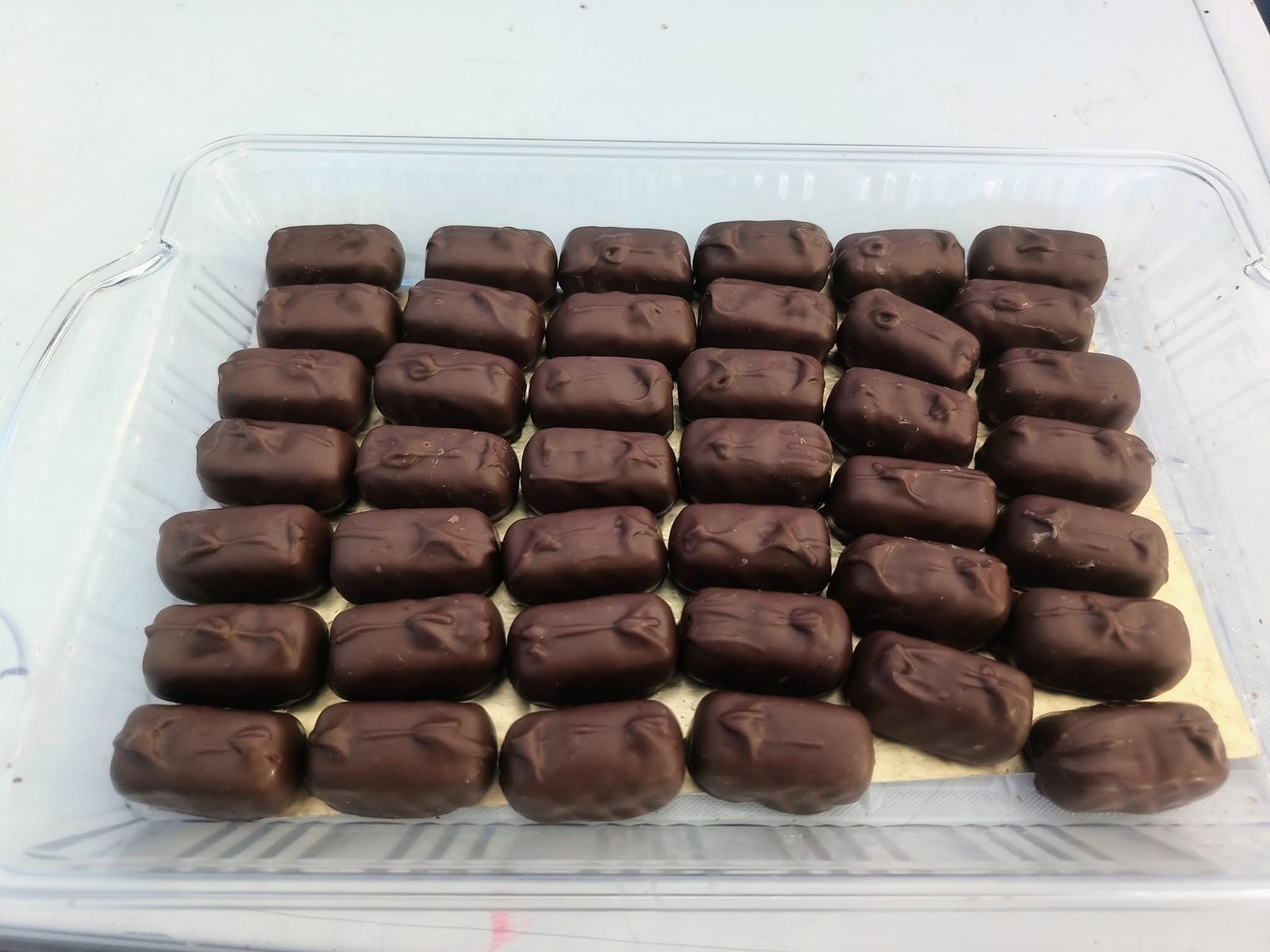 Chocolate-covered caramels lined up in rows at The Candy Shoppe on Main