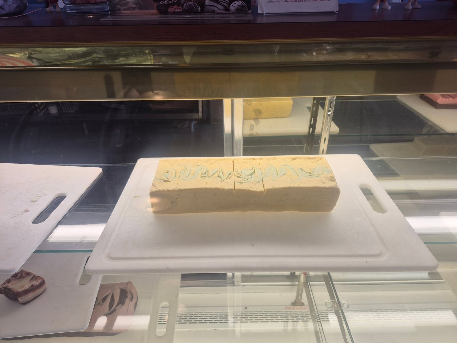 Fudge slab on the cutting board in the display case at The Candy Shoppe on Main