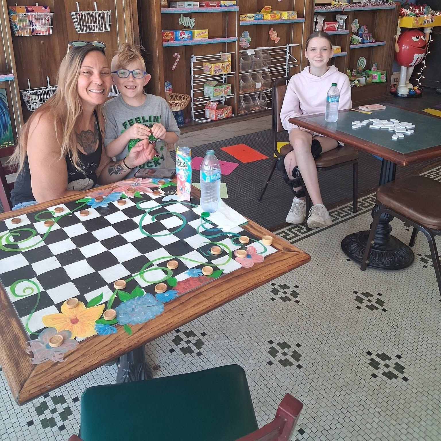 A family playing checkers at a table inside The Candy Shoppe on Main